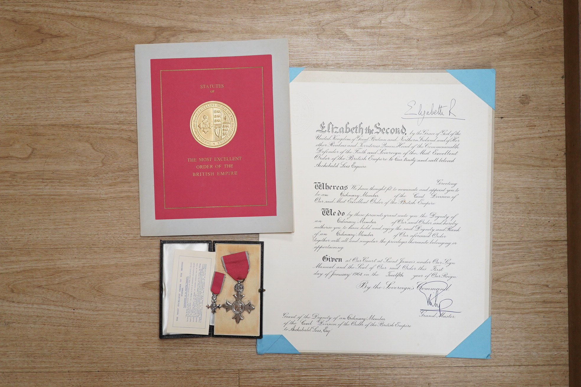 An MBE for Archibald Lees with miniature and an Imperial Service Medal for Thomas Lees, a silver coaster and silver match case with coronet over ‘E’ and ‘Holyrood 1925’ to reverse